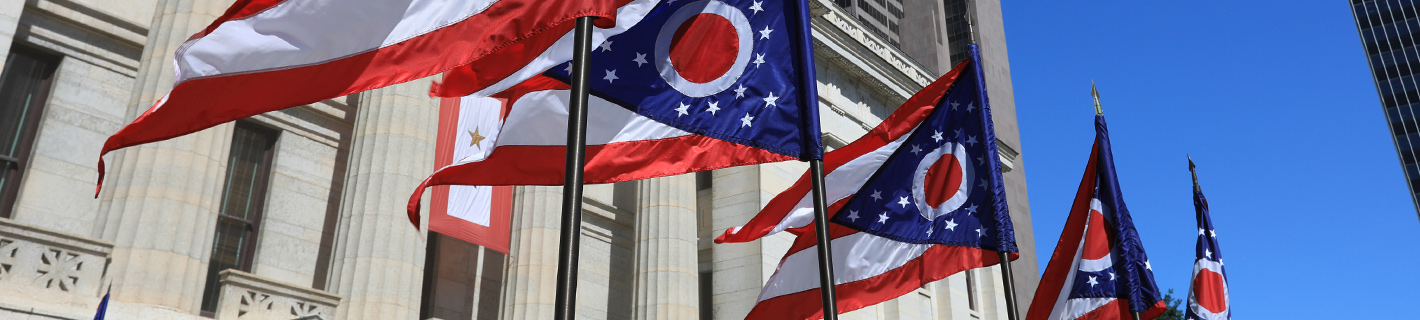 The Statehouse in Columbus, Ohio with several state flags being flown.